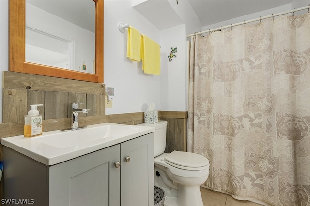 bathroom with tile walls, tile patterned flooring, toilet, and vanity