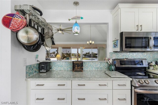 kitchen featuring white cabinets, ceiling fan with notable chandelier, light stone counters, stainless steel appliances, and decorative backsplash