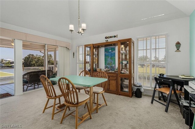 carpeted dining area featuring a notable chandelier