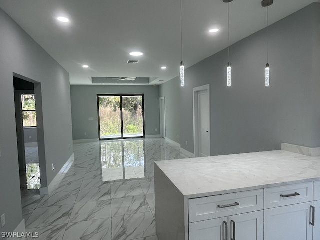 interior space with pendant lighting, white cabinetry, light tile floors, and light stone countertops