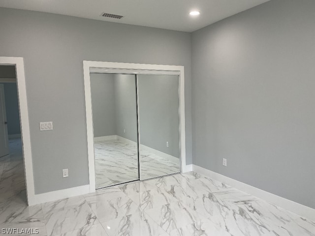 unfurnished bedroom with a closet and light tile floors