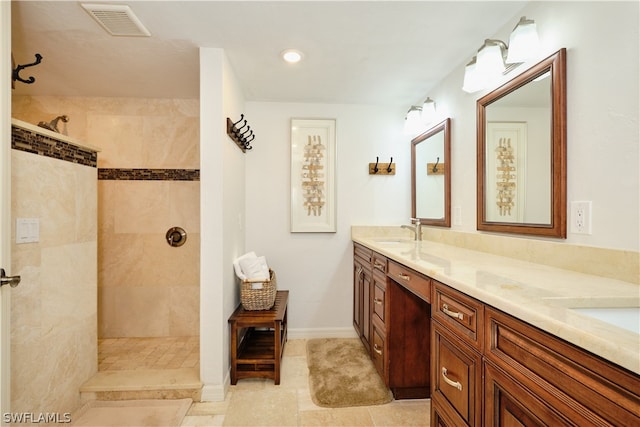 bathroom featuring tile patterned flooring, vanity, and tiled shower