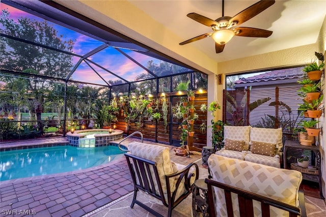 pool at dusk with ceiling fan, glass enclosure, an in ground hot tub, and a patio