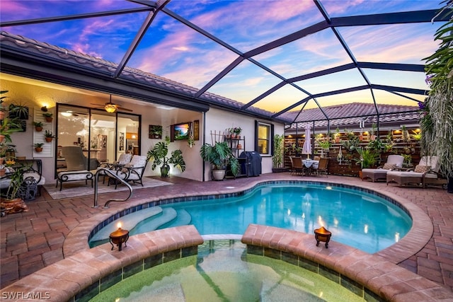 view of swimming pool with a lanai, ceiling fan, a patio area, and an in ground hot tub