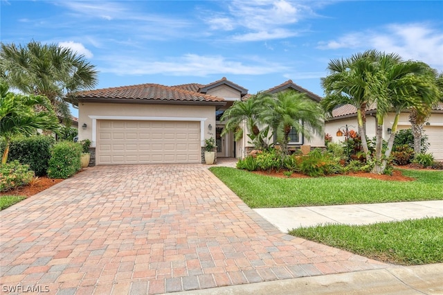 mediterranean / spanish home with a garage and a front lawn