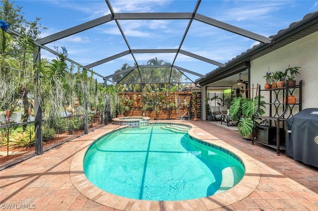 view of pool featuring glass enclosure, area for grilling, a patio area, and an in ground hot tub