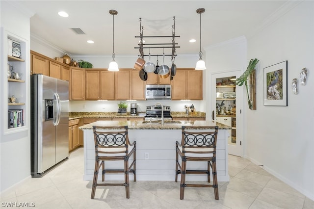 kitchen featuring light stone countertops, sink, an island with sink, decorative light fixtures, and appliances with stainless steel finishes