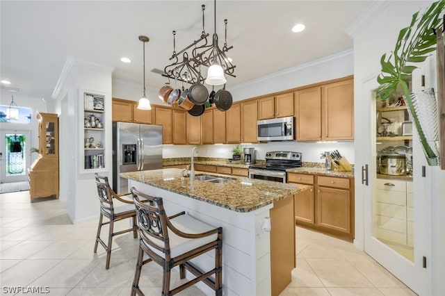 kitchen with sink, stainless steel appliances, a center island with sink, light tile patterned floors, and ornamental molding