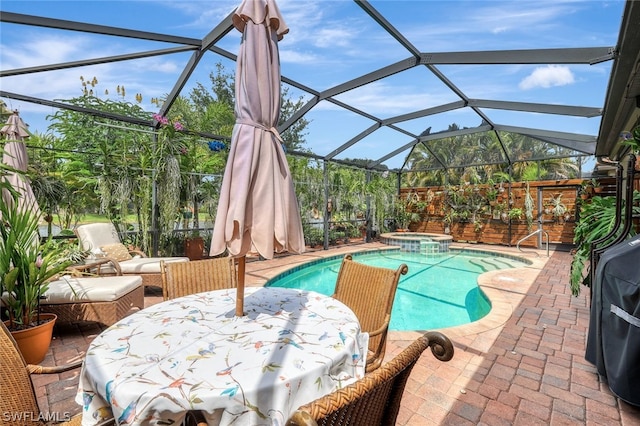 view of pool with glass enclosure, a patio area, and an in ground hot tub