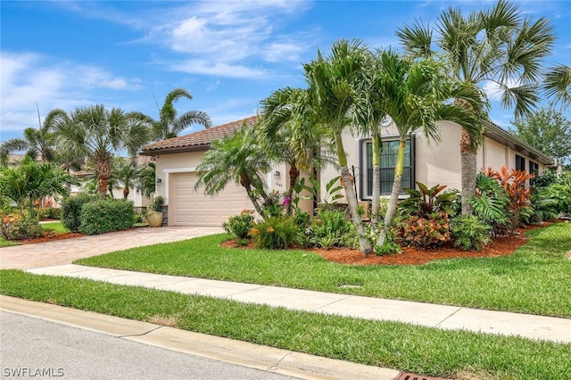 mediterranean / spanish house featuring a garage and a front yard