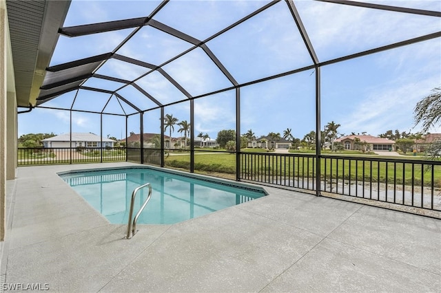 view of pool with a yard, a patio area, and glass enclosure