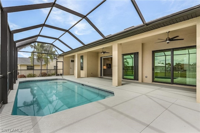 view of pool featuring a patio area, glass enclosure, and ceiling fan