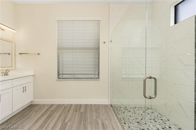 bathroom with hardwood / wood-style flooring, walk in shower, and vanity