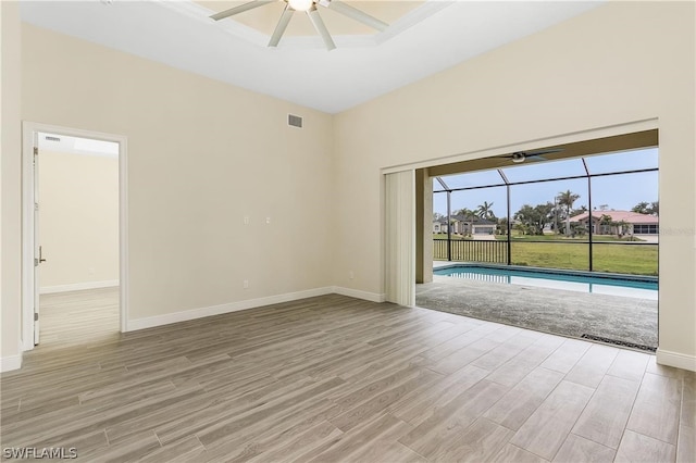 empty room with ceiling fan and light hardwood / wood-style flooring