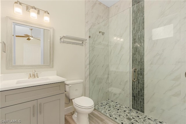 bathroom with an enclosed shower, oversized vanity, ceiling fan, and toilet