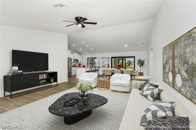 living room with light hardwood / wood-style flooring, ceiling fan, and lofted ceiling