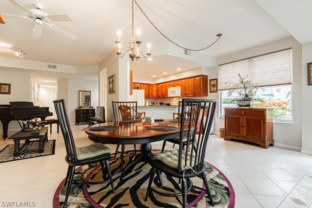 dining space with light tile patterned floors and ceiling fan with notable chandelier