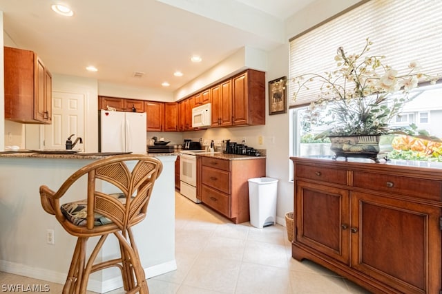 kitchen featuring white appliances, sink, and light tile patterned floors