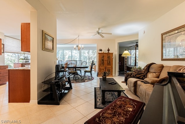 living room with plenty of natural light, light tile patterned flooring, and ceiling fan with notable chandelier