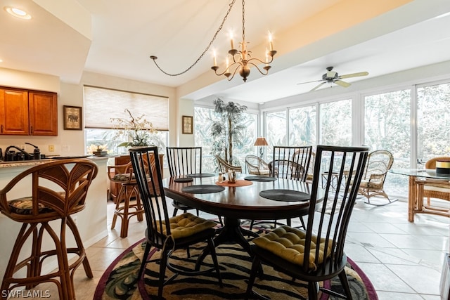 tiled dining room featuring ceiling fan with notable chandelier