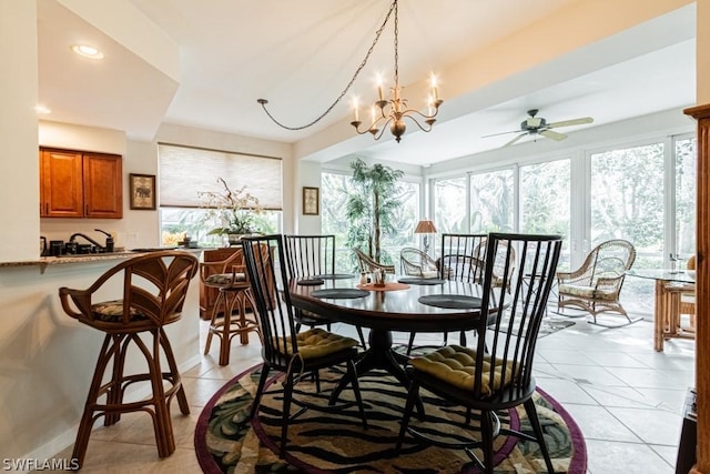 tiled dining area featuring plenty of natural light and ceiling fan with notable chandelier