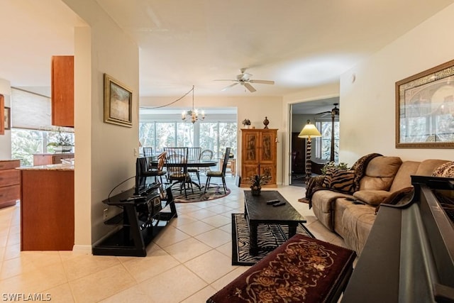 tiled living room with a healthy amount of sunlight and ceiling fan with notable chandelier