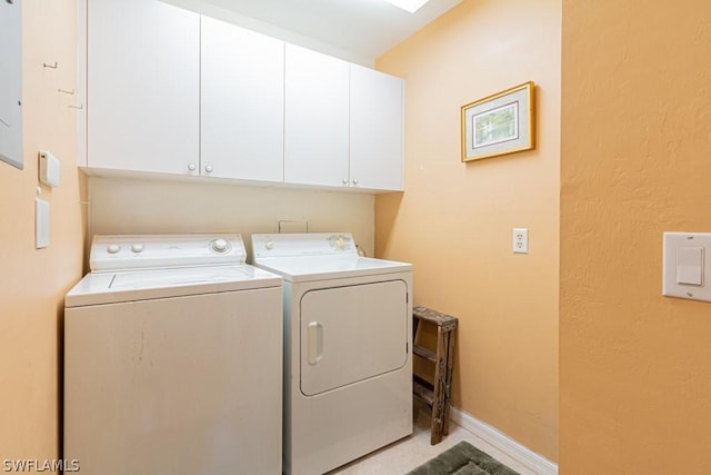 clothes washing area featuring washer and dryer and cabinets