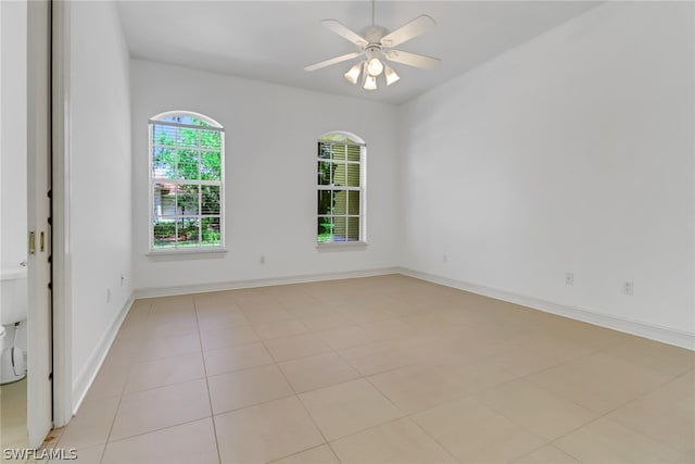 tiled spare room featuring ceiling fan