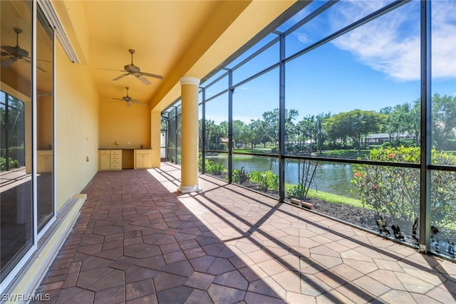 unfurnished sunroom featuring a water view and ceiling fan