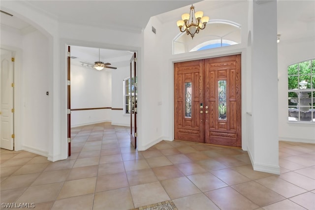 entryway with light tile floors and ceiling fan with notable chandelier