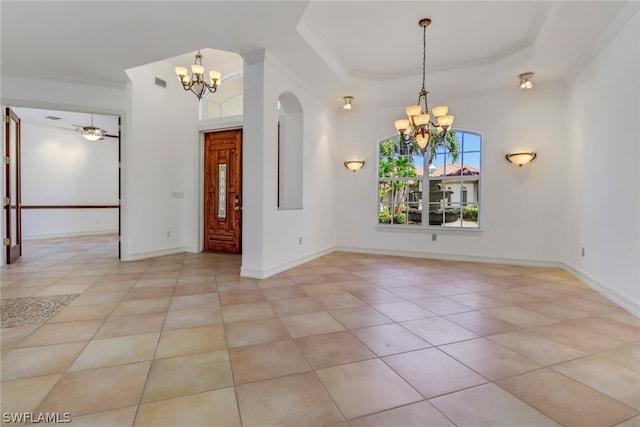 empty room with ceiling fan with notable chandelier, light tile flooring, and a raised ceiling