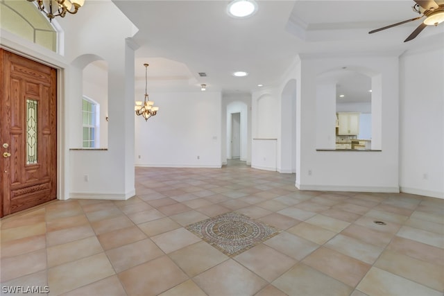 foyer featuring crown molding, ceiling fan with notable chandelier, light tile floors, and a raised ceiling