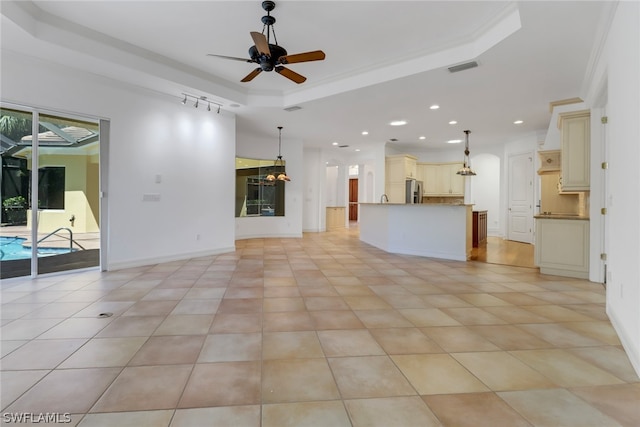 unfurnished living room featuring light tile floors, ceiling fan, and a raised ceiling