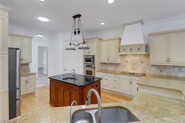 kitchen featuring appliances with stainless steel finishes, tasteful backsplash, light stone countertops, premium range hood, and hanging light fixtures