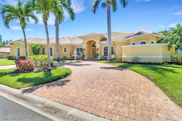 mediterranean / spanish-style house featuring a front lawn