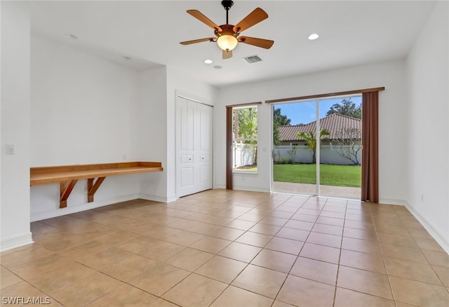 tiled empty room featuring ceiling fan