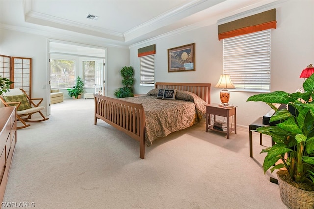 carpeted bedroom featuring crown molding and a tray ceiling