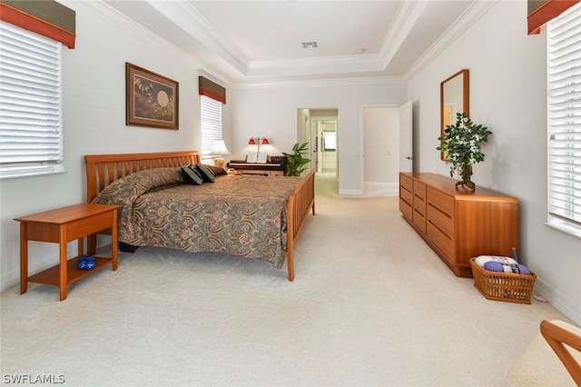 carpeted bedroom featuring a tray ceiling, ornamental molding, and multiple windows