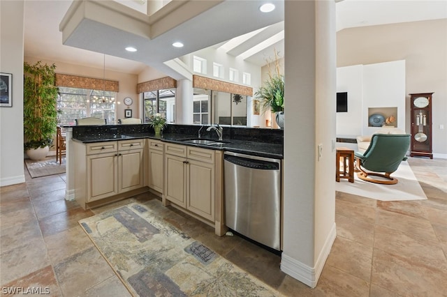 kitchen with dark stone counters, dishwasher, sink, and light tile floors