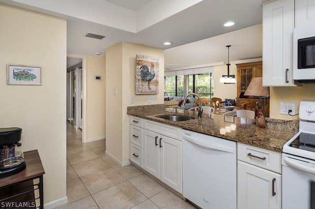 kitchen featuring white cabinetry, dark stone countertops, light tile floors, white appliances, and sink