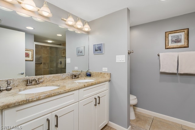 bathroom with toilet, vanity with extensive cabinet space, tile flooring, dual sinks, and an enclosed shower