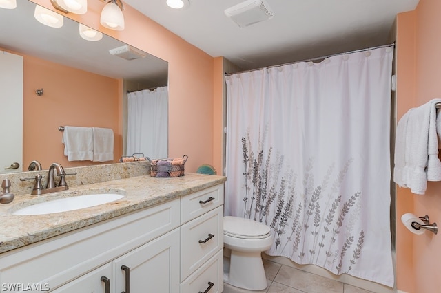 bathroom featuring tile floors, oversized vanity, and toilet