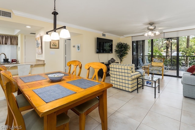 dining area featuring crown molding, light tile flooring, and ceiling fan