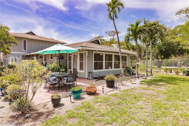 rear view of property with a lawn and a patio area