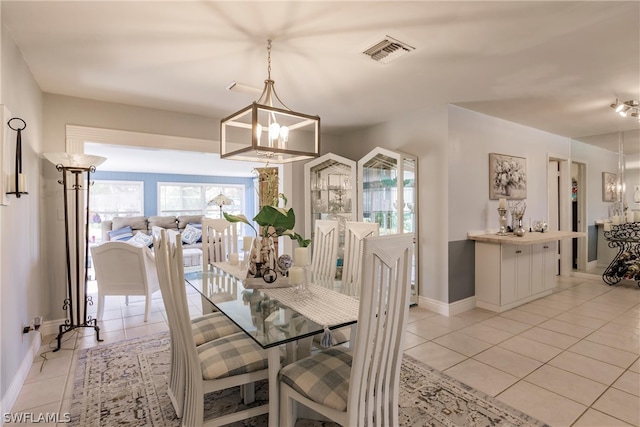 tiled dining space featuring a notable chandelier