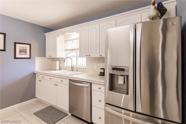 kitchen featuring white cabinets, light tile floors, stainless steel appliances, backsplash, and sink