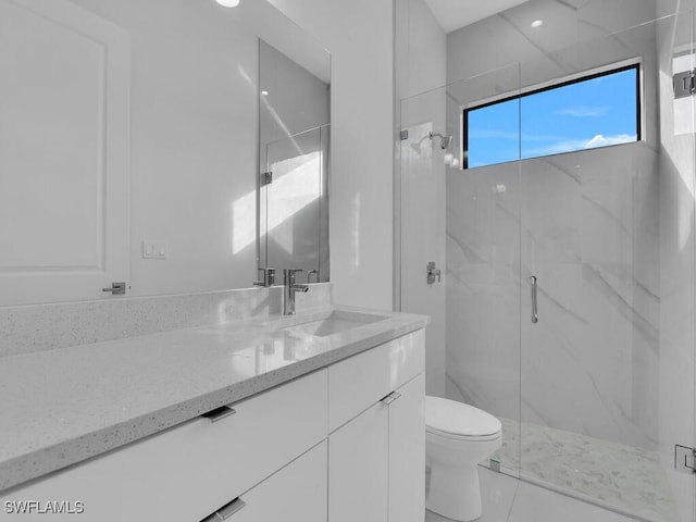 bathroom featuring vanity, an enclosed shower, and toilet