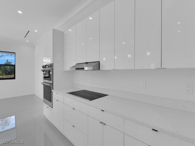 kitchen featuring white cabinets, crown molding, light stone countertops, black electric cooktop, and double oven