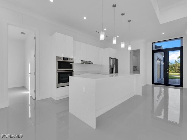 kitchen featuring french doors, ornamental molding, multiple ovens, pendant lighting, and white cabinets