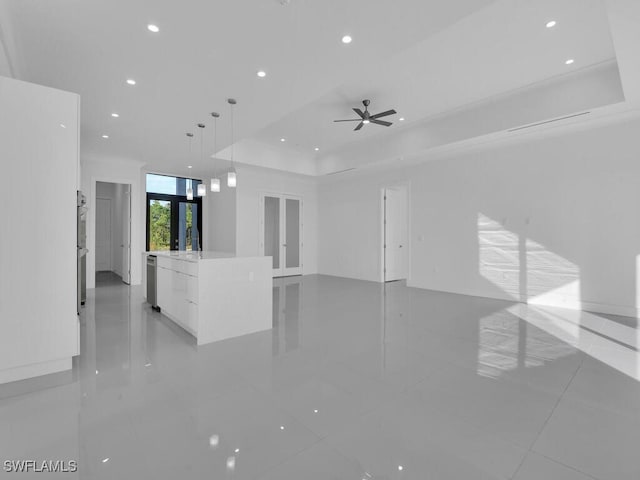 unfurnished living room featuring a raised ceiling, ceiling fan, french doors, and light tile patterned floors